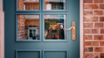 Man in Black Sweater Taking Photo of Blue Door