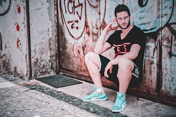 Man In Black T-shirt And Shorts Leaning on Wall