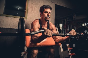 Man in Black Tank Top Holding Exercise Equipment