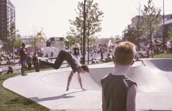 Man in Black Tank Top Looking at Man in Black T-shirt Doing Hand Stand Routine