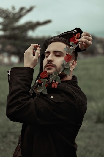 Man in Black Top Holding Red Flowers