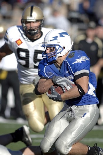 Man in Blue and Silver Football Uniform Carrying Football