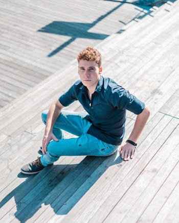 Man in Blue Collared Shirt and Blue Trousers Sitting Down on Wooden stairs 