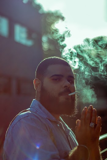 Man In Blue Collared Shirt Puffing Cigarette