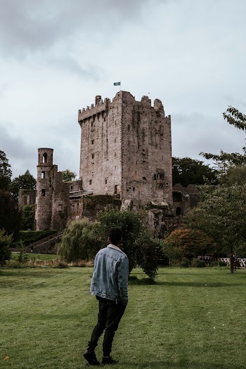 Man in Blue Denim Jacket Looking on Castle