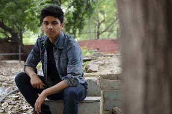 Man in Blue Denim Jacket Sits on Platform Concrete