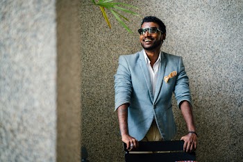 Man in Blue Formal Jacket in Front of Black Wooden Chair