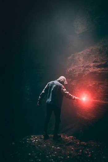 man in blue hoodie holding flare stick