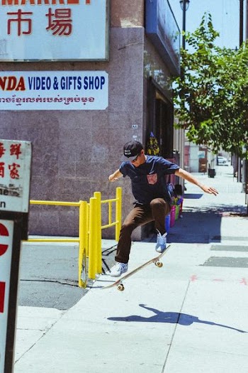 man in blue shirt skateboarding on gray surface