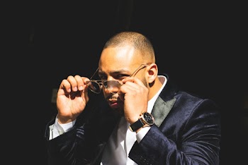 Man in Blue Suit Jacket Taking Off Sunglasses