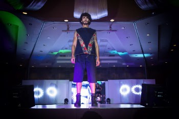 Man in Blue Top and Bottoms Standing on Stage