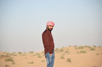 Man in Brown Collared Dress Shirt and Blue Jeans Standing in the Middle of Brown Field