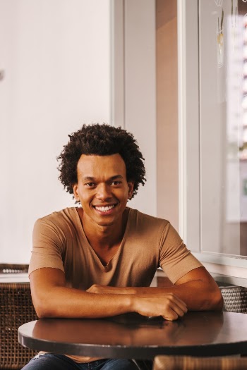 Man in Brown Crew Neck T-shirt Sitting on Chair