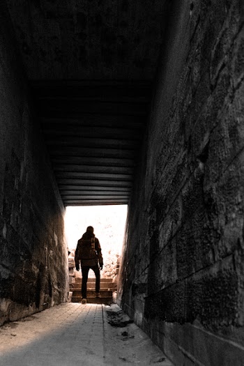 Man in Brown Jacket and Pants Near Gray Alley