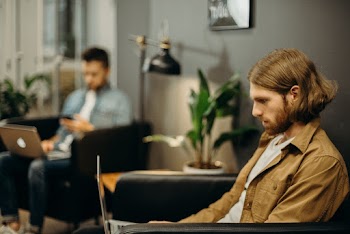 Man in Brown Jacket Using Macbook