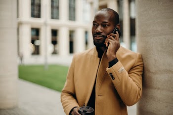 Man in Brown Overcoat Using Smartphone
