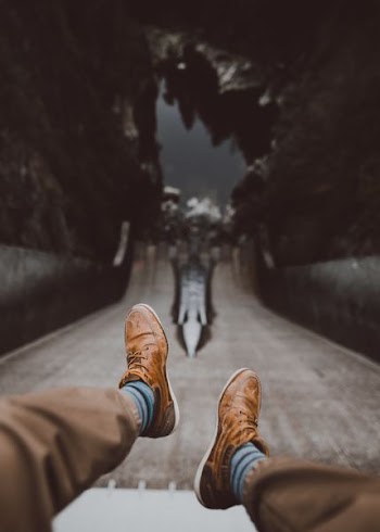 man in brown pants wearing low-top shoes in tilt shift photography