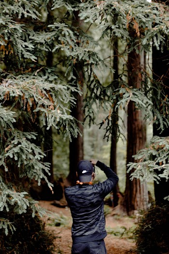 Man in Cap Standing Near Trees