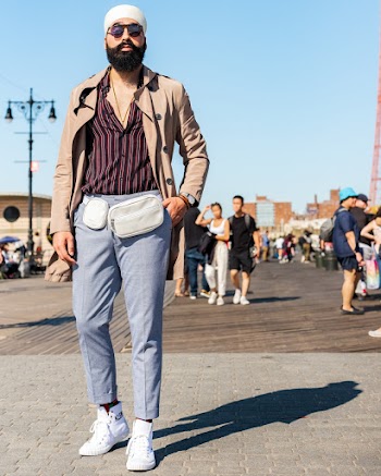 Man  In Casual Clothing And A Waist Bag Standing On A Paved  Walkway 