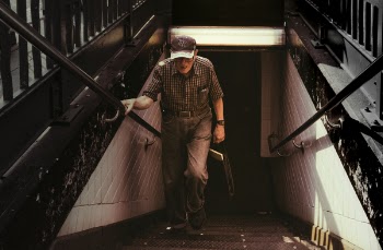 Man in Collared Shirt and Gray Pants Walking on Stairs