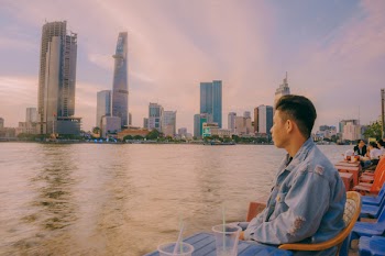 Man in Denim Jacket Sitting Near Body of Water