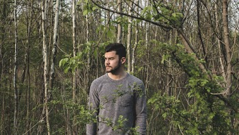 Man in Gray Crew-neck Long-sleeved Shirt Standing Near Plants