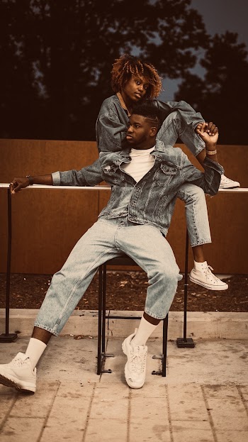 Man in Gray Denim Jacket Leaning on Woman