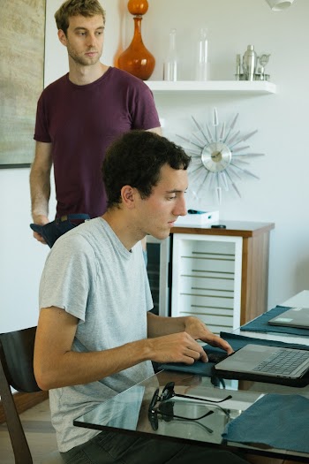 Man in Gray Shirt Siting While Facing Laptop