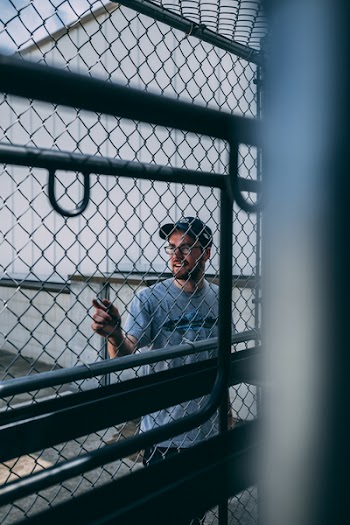 Man in Gray Steel Cyclone Fence