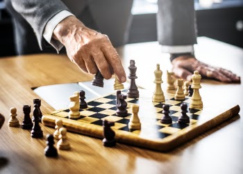 Man in Gray Suit Playing Chess