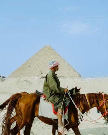 Man in Gray Thobe Riding Brown Horse · Free Stock Photo