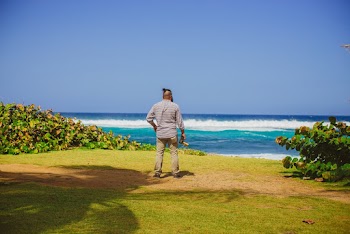 Man in Gray Top and Pants Facing Ocean
