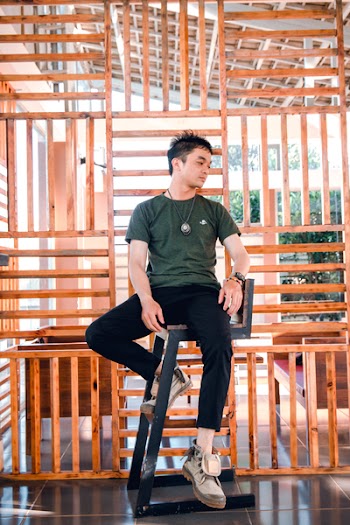 Man in Green Crew-neck Shirt Sitting on Black Wooden Chair