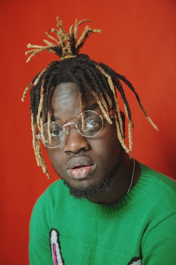 Man in Green Crew-neck Sweater Near Red Wall