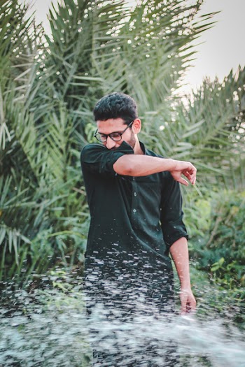 Man in Green Dress Shirt Near Palm Trees