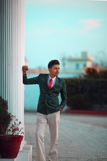 Man in Green Suit Jacket Leaning Right Hand on Column