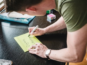 Man in Green T-shirt and Silver Watch Holding Yellow Sticky Notes