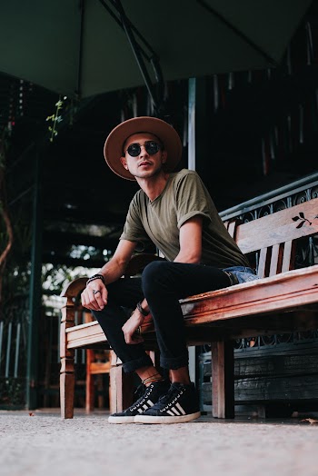 Man in Green T-shirt Sitting on Brown Wooden Bench