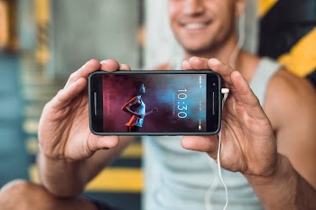 Man in gym holding smartphone mockup Free Psd