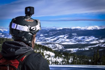 Man in Helmet With Action Camera Looking at Snow Mountain