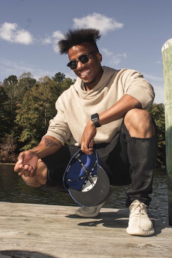 Man In Hoodie And Black Pants Posing For Photo