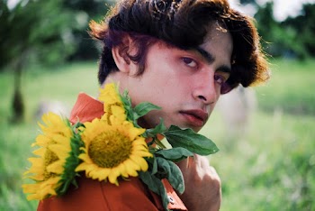 Man In Orange Collared Shirt Holding Sunflowers