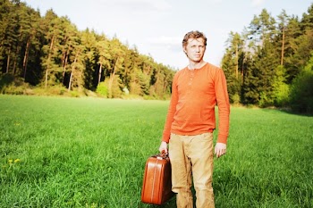 Man in Orange Henley-neckline Shirt Holding Suitcase