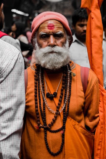 Man in Orange Suit With Red Marking on Forehead
