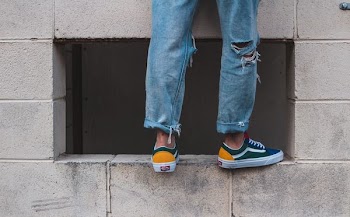 man in pair of green-and-white low-top vans