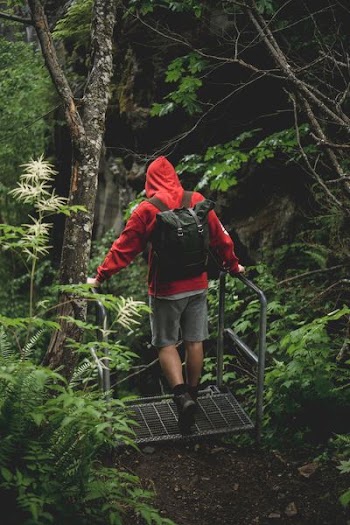 man in red and white hoodie standing on metal frame