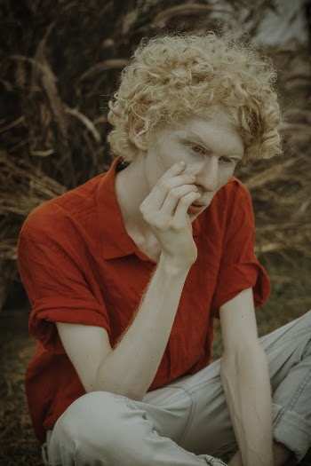 Man in Red Polo Shirt Sitting on Ground