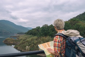 Man in Red, Yellow, Blue,and White Plaid Collared Top With Blue and Gray Backpack
