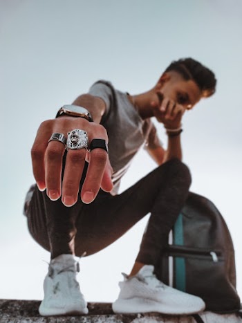 Man in Squat Position Beside Backpack
