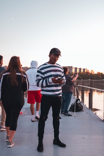 Man in Striped Long-sleeved Shirt and Black Pants Outfit by Body of Water